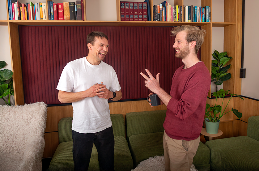 two employees share coffee and smiles