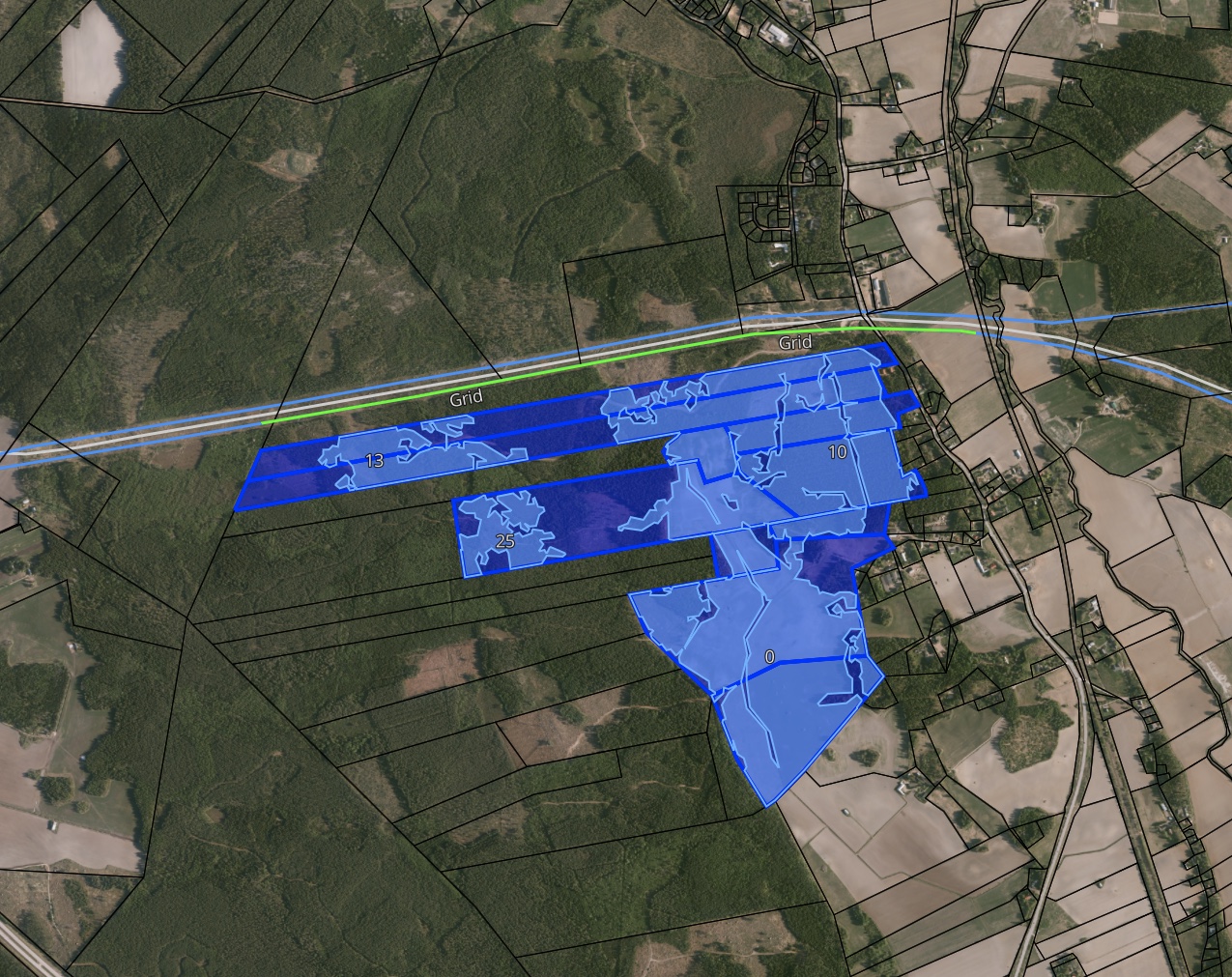 Buildable area screening in Glint Solar, with buildable parcels highlighted in blue along a grid corridor over satellite imagery